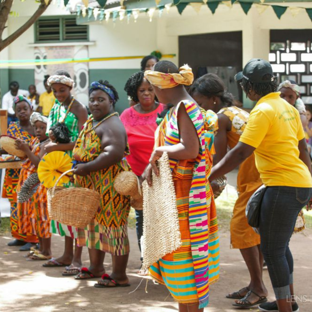 Young people dancing and holding traditional baskets.